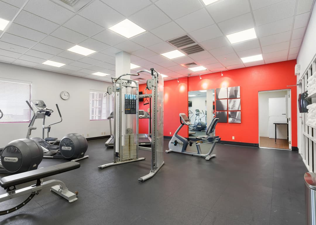 The gym at Thousand Hills at the time showing an eliptical, seated bike, cable machine, bench and treadmills.