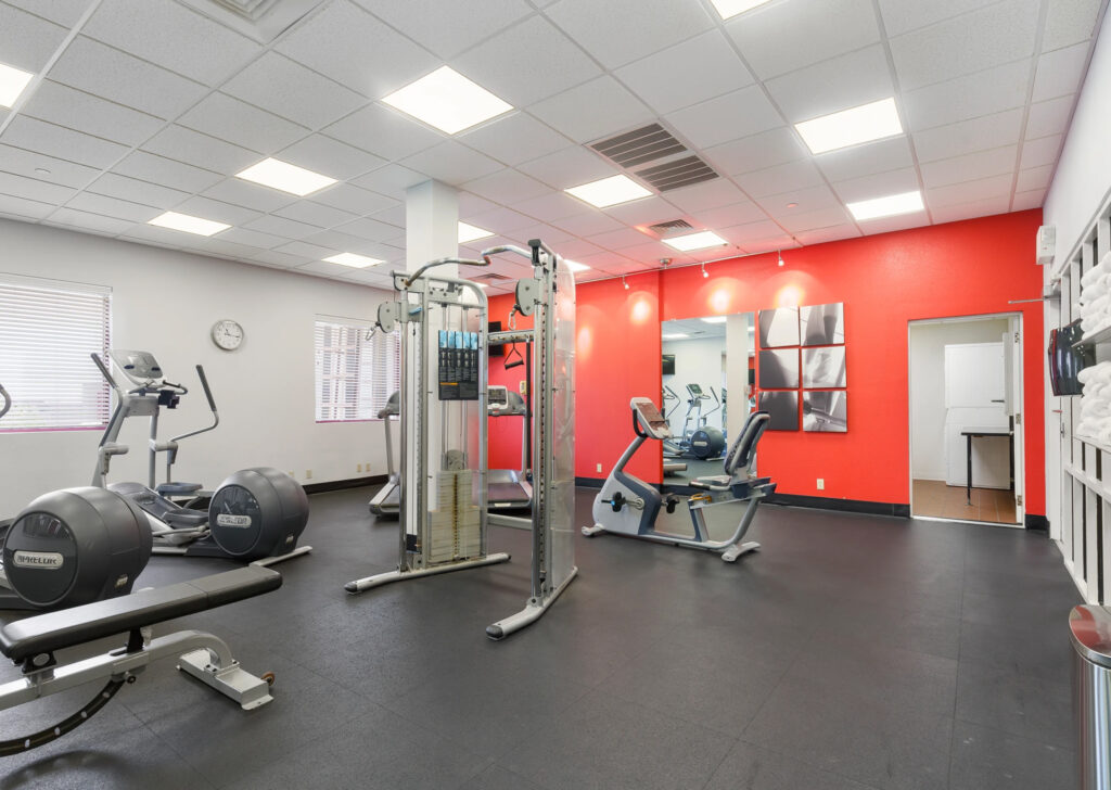 The gym at Thousand Hills at the time showing an eliptical, seated bike, cable machine, bench and treadmills.